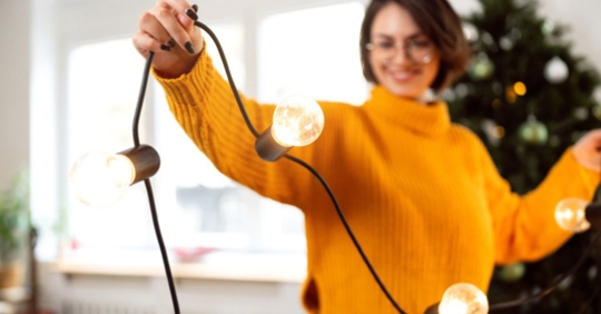 woman putting up holiday lights